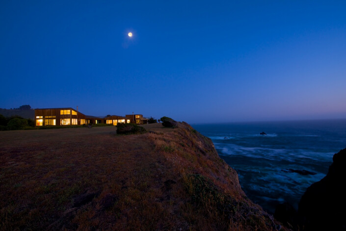 Modern california coastal home at dusk sea arches