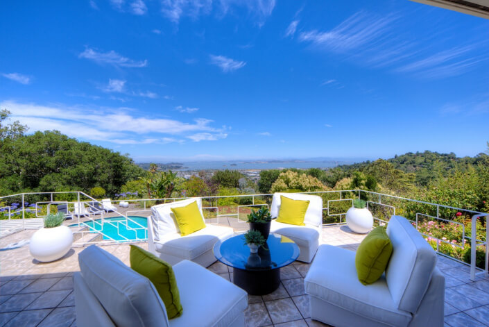 Upper deck seating area with white chairs and green cushions