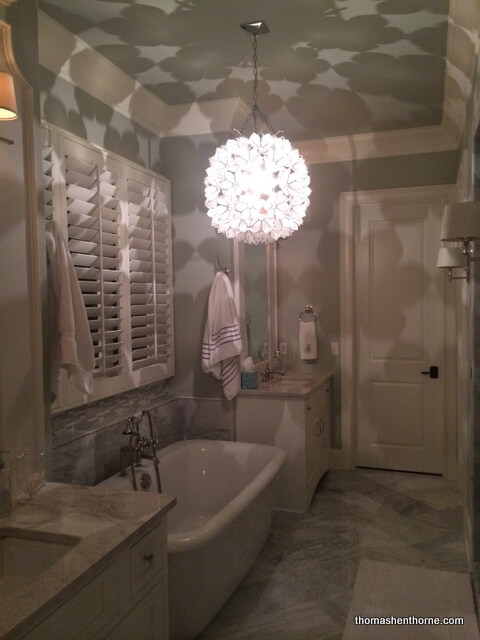 photo of light fixture in bathroom casting patterned shadows all over the walls