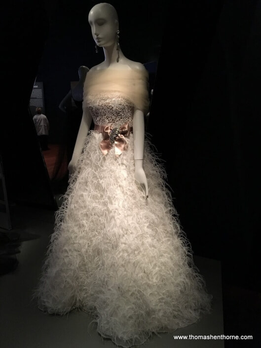 white dress of ostrich feathers with pink satin bow