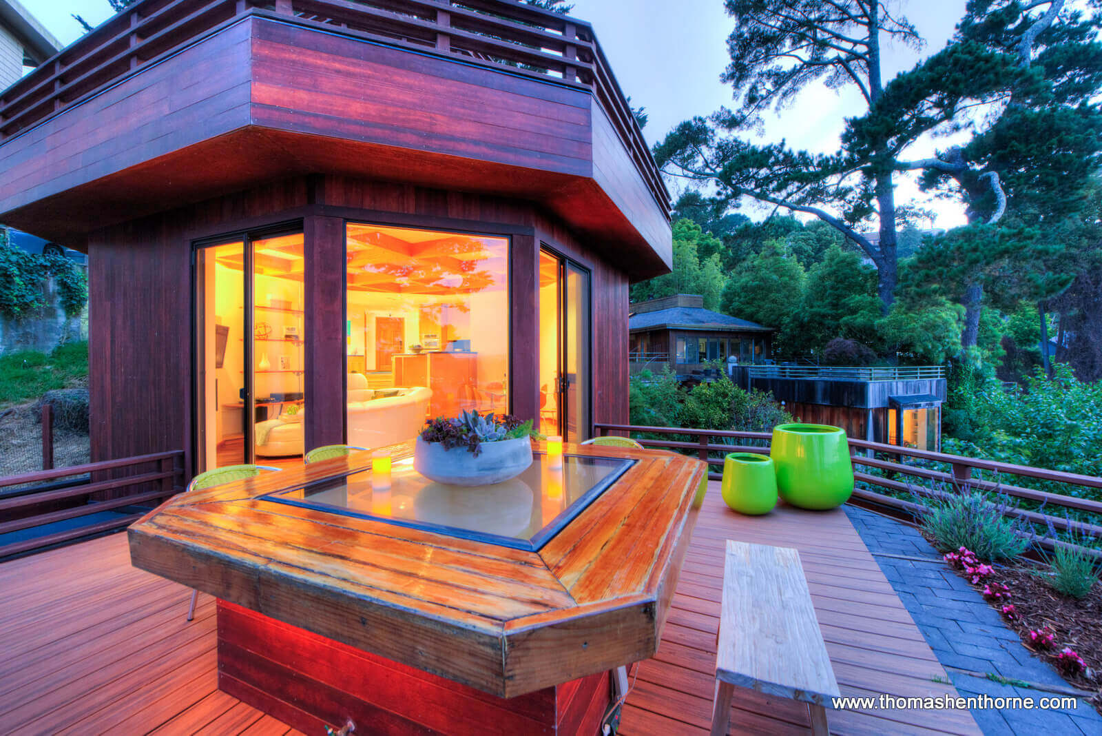 Photo of outdoor table with green pots in background