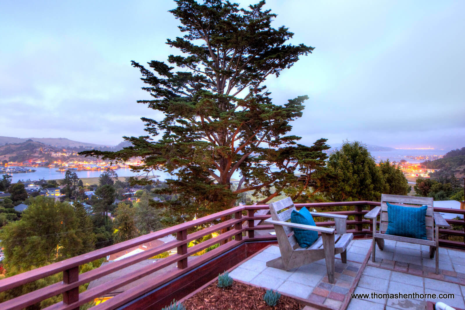 View of outdoor deck with two chairs and bay in distance