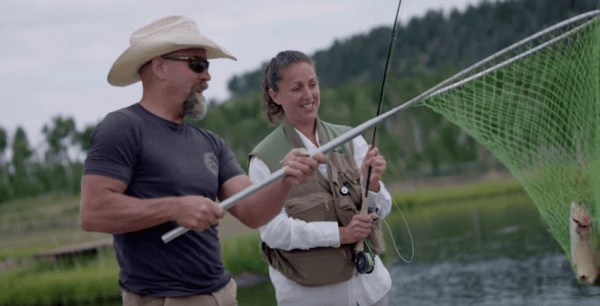 Photo of Liz O'Neill and John Nelson catching a fish from trout pond in Houseguest Episode Three