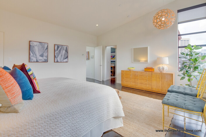 Photo of bedroom with two yellow chairs and modern hanging lamp