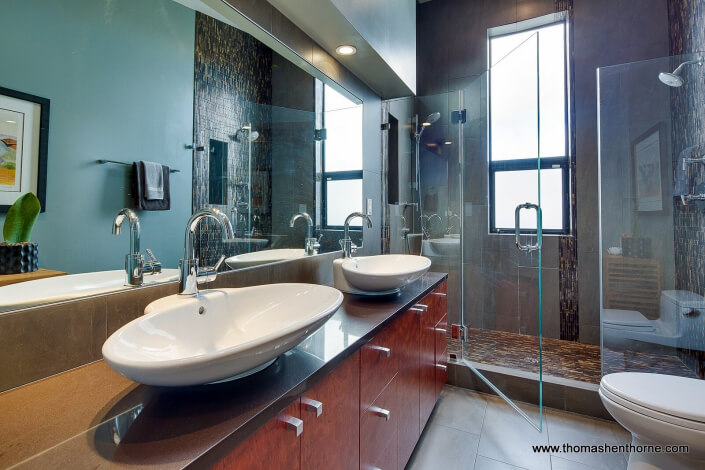 Master bathroom with dual vessel sinks and glass enclosed shower with view