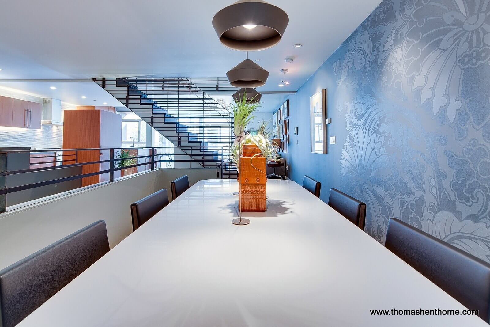 Dining area on mezzanine level with stairway in background