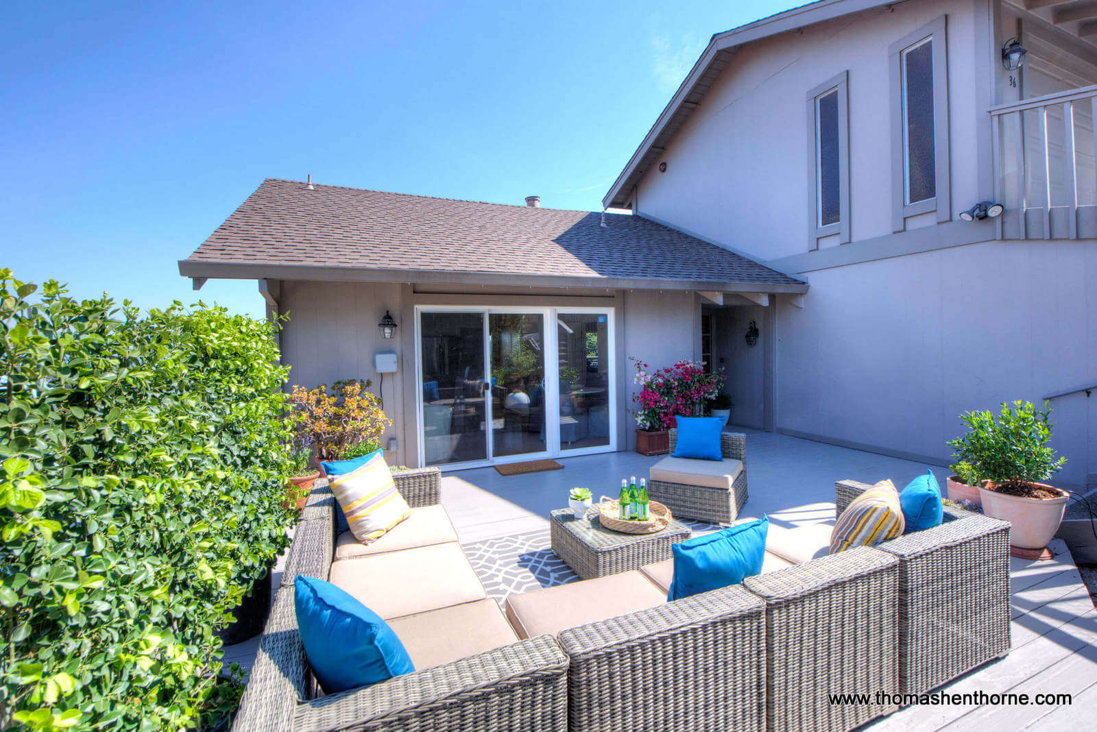 Front of home with deck leading to kitchen sliding doors