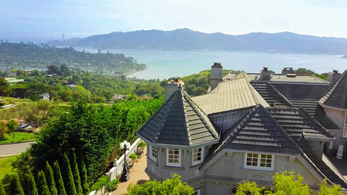 Aerial view of home's roof with bay in background