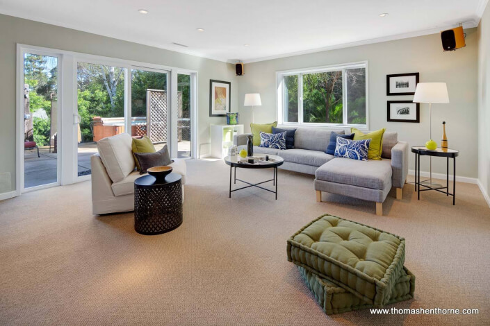 Media room with sectional sofa and sliding doors to hot tub outside