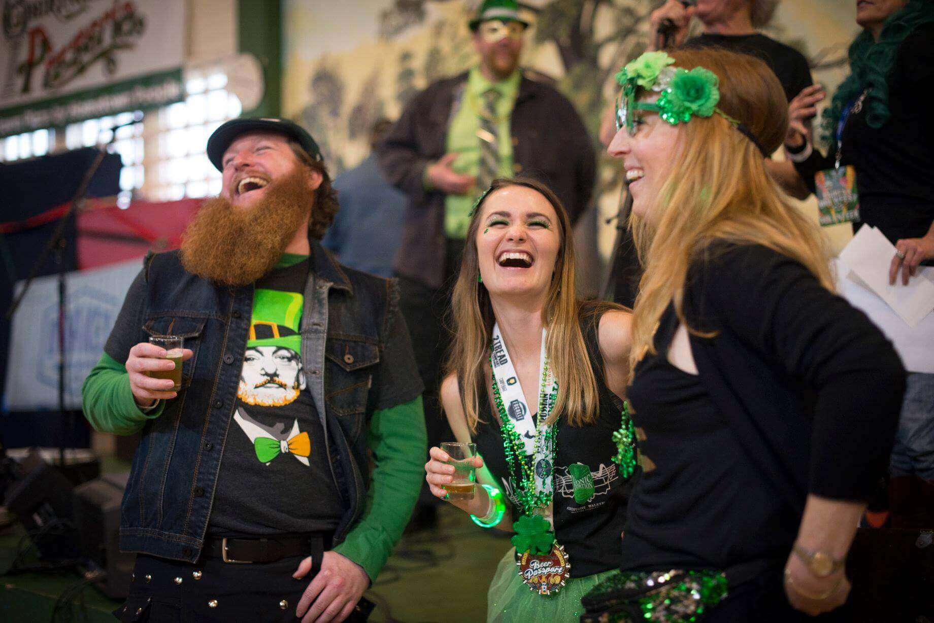 People laughing drinking beer and dressed for St. Patrick's Day