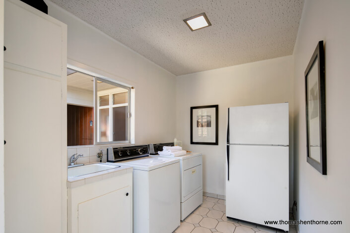 Laundry room with refrigerator