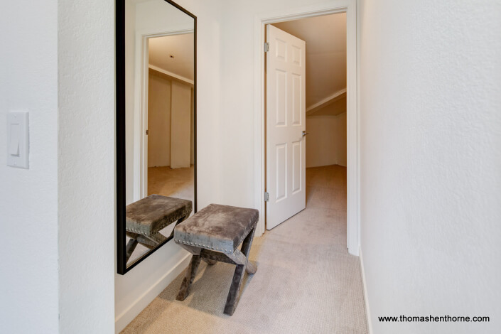 Hallway with mirror and door open to storage room