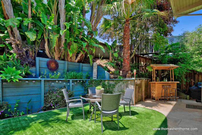 Table and four chairs with tiki bar in background