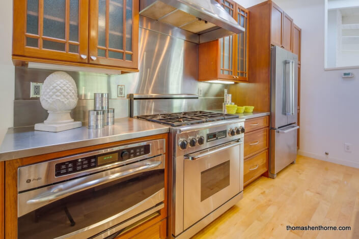 Kitchen with stainless appliances and hood