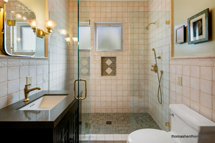 Bathroom with custom tilework and brass fixtures