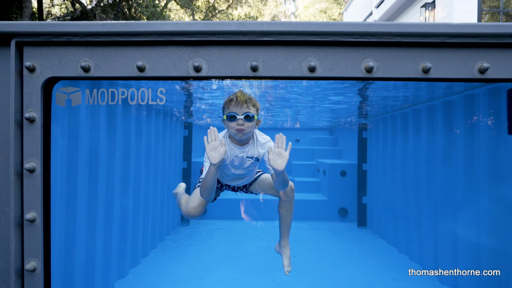 Boy swimming in Modpool with glass sides