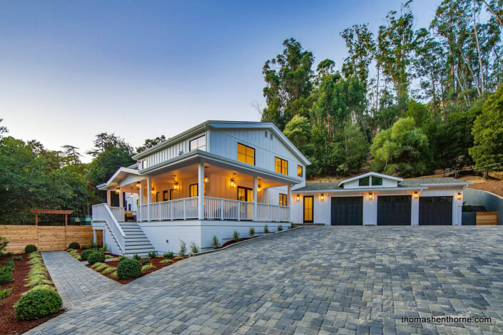 Modern farmhouse home with paver driveway and three-car garage