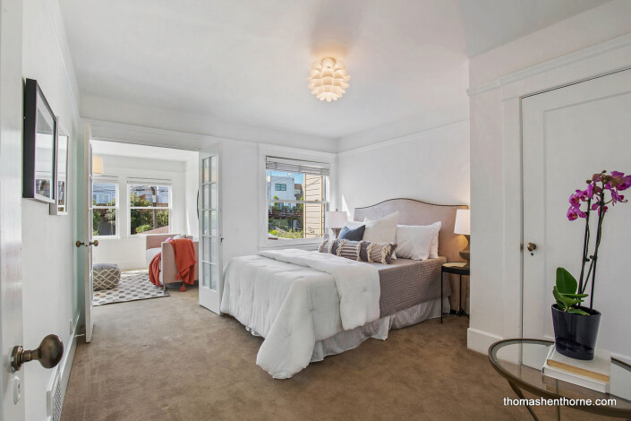 Bedroom opening to sunroom through French doors