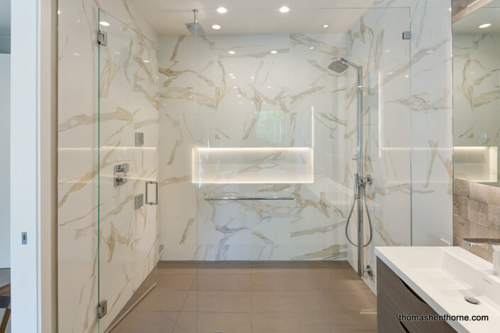 Walk-in marble clad shower with dual shower heads