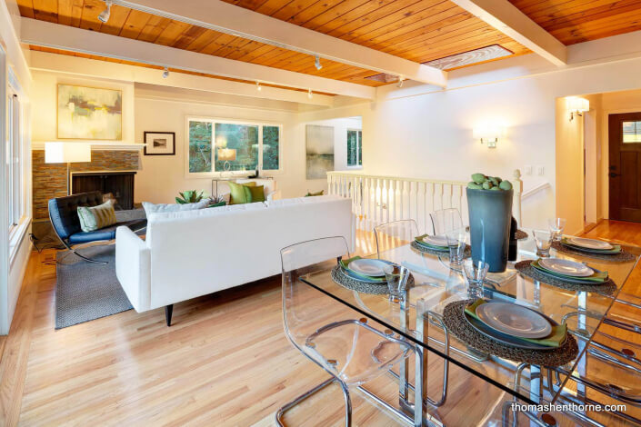 Glass dining table with living room in background