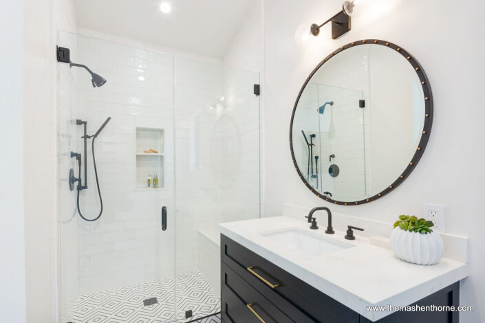 Bathroom with walk in shower and vanity with round mirror
