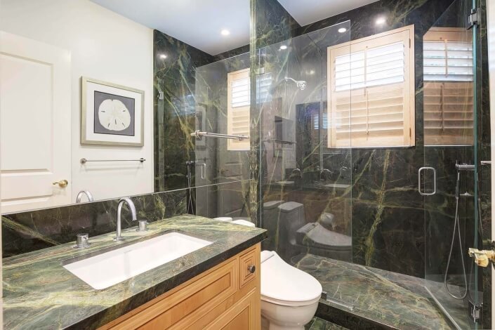 bathroom with stone countertops and glass shower