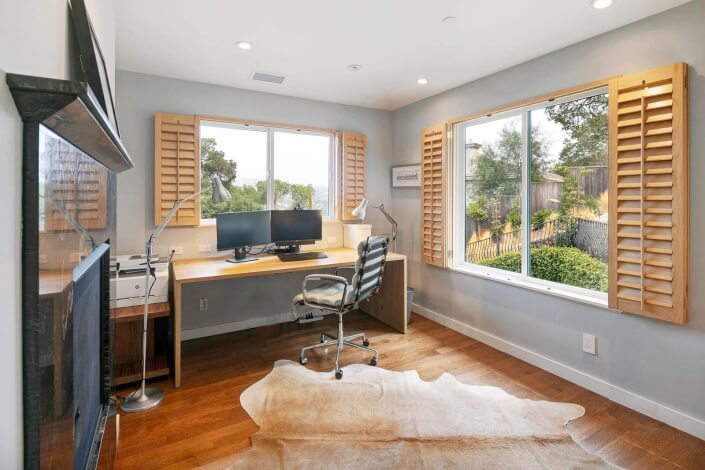 home office with wood floors and two windows