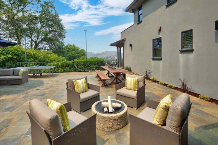 outdoor firepit with four chairs on stone terrace