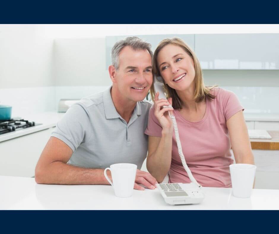 couple using landline in kitchen