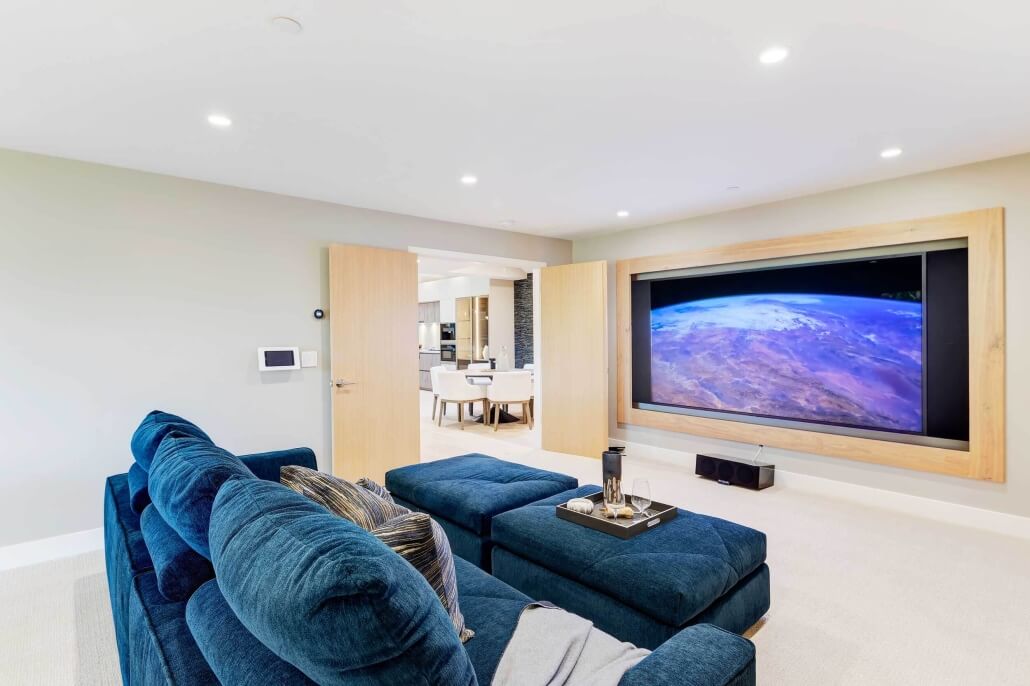 media room with blue sofa and large screen display
