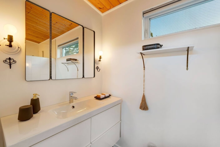 Bathroom vanity with mirror and shelf below window