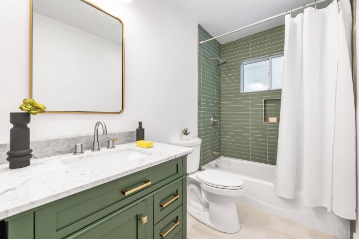 bathroom with green tile and vanity