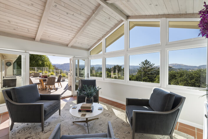 Open beamed room with views of hills through windows