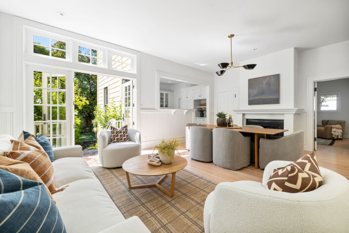 Large room with glass french doors and dining table and sofa