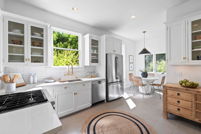 Kitchen with stainless appliances and tile backsplash and open shelving