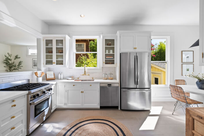 Kitchen with stainless appliances and tile backsplash and open shelving