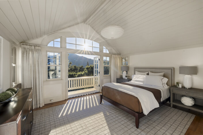 Primary bedroom with sun shining through windows star effect