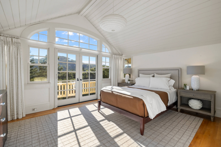 primary bedroom with sun streaming in through french doors